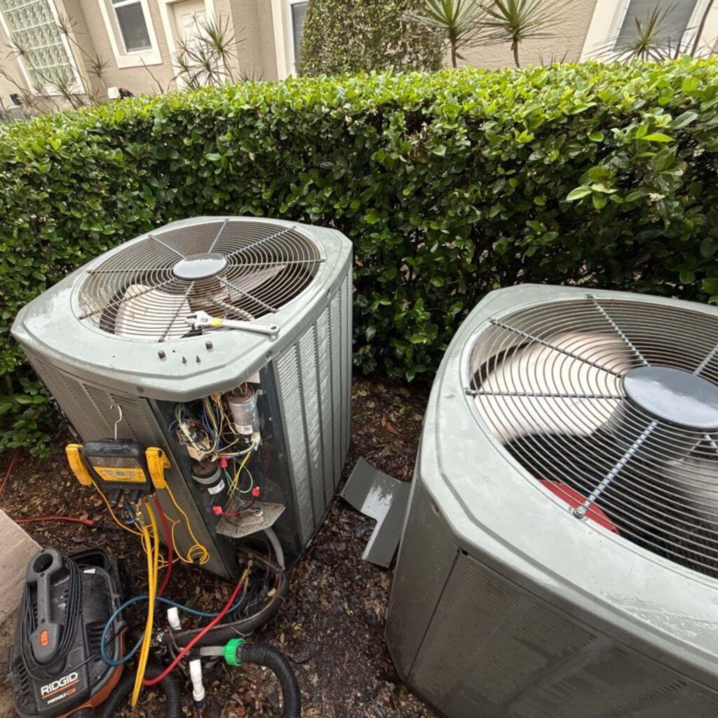 Two outdoor condensers being tested with a meter